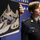 La policía con uno de las zapatillas encontradas. Canadian Press